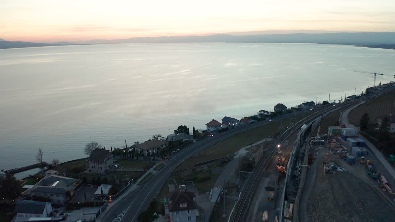 antena de un pequeño pueblo en construcción cerca de un gran lago al atardecer