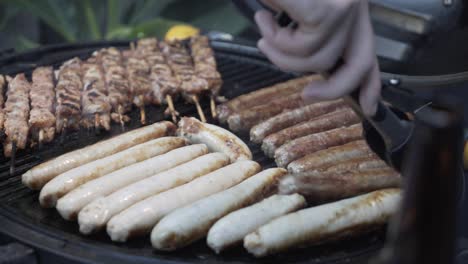 grill master flipping sausages for guests on gas barbecue