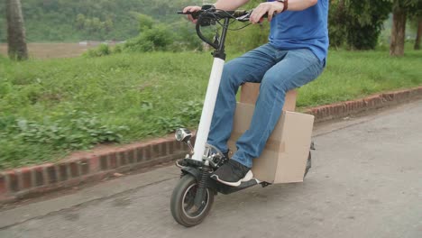 man rides a electric scooter on the road to deliver orders and packages for customers