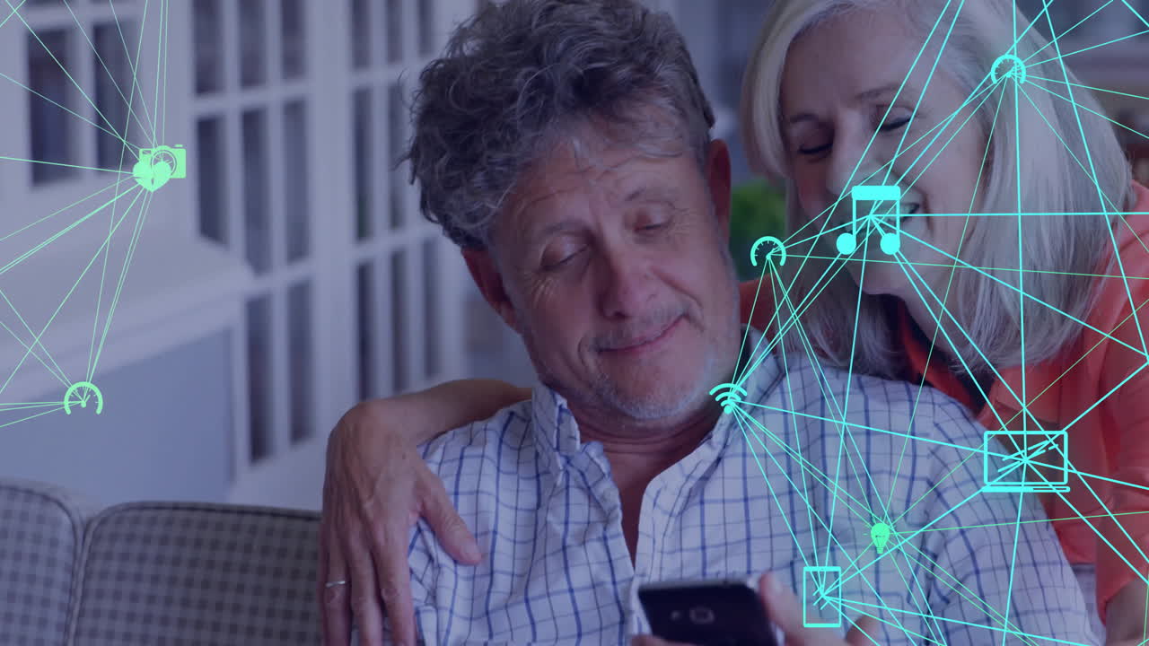 Senior couple sitting on couch using smartphone, showing tech connectivity icons and Wi?Fi symbols