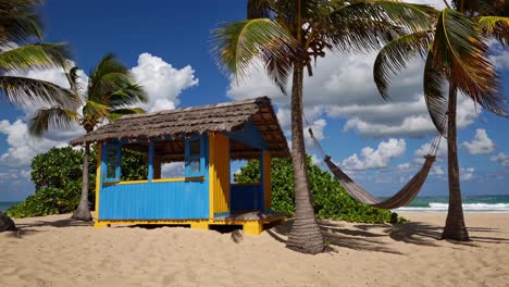 Tropical beach scene with a colorful hut and hammock under palm trees