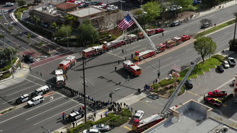 camiones de bomberos y otros socorristas esperan una procesión fúnebre