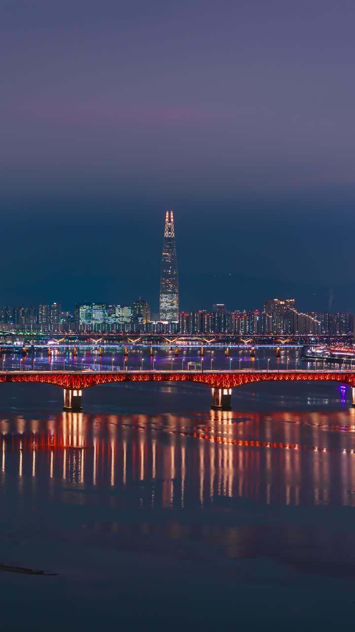 Time lapse verticale ad angolo elevato di un tramonto invernale su Seul, che mostra il fiume Han, il traffico sul ponte Seongsu e la Lotte World Tower mentre il cielo passa a un'ora blu intenso