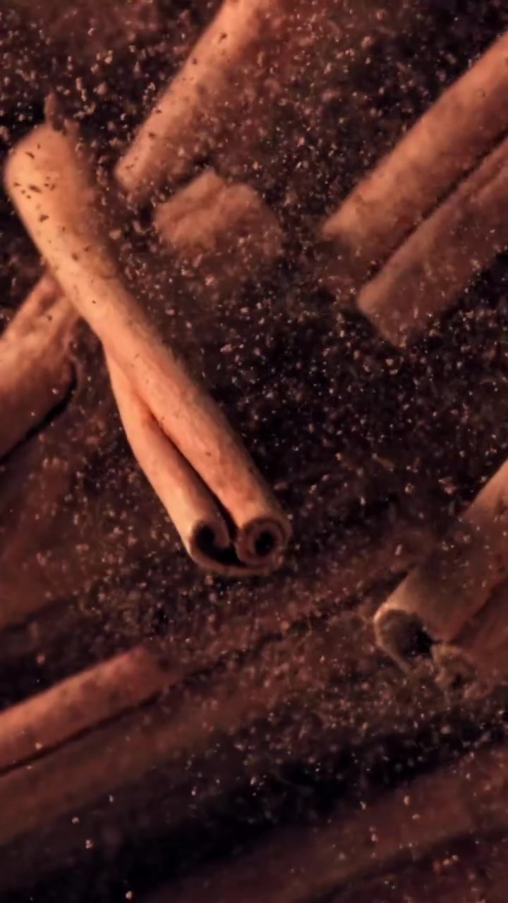 Kanelstenger og kanelpulver faller i sakte film