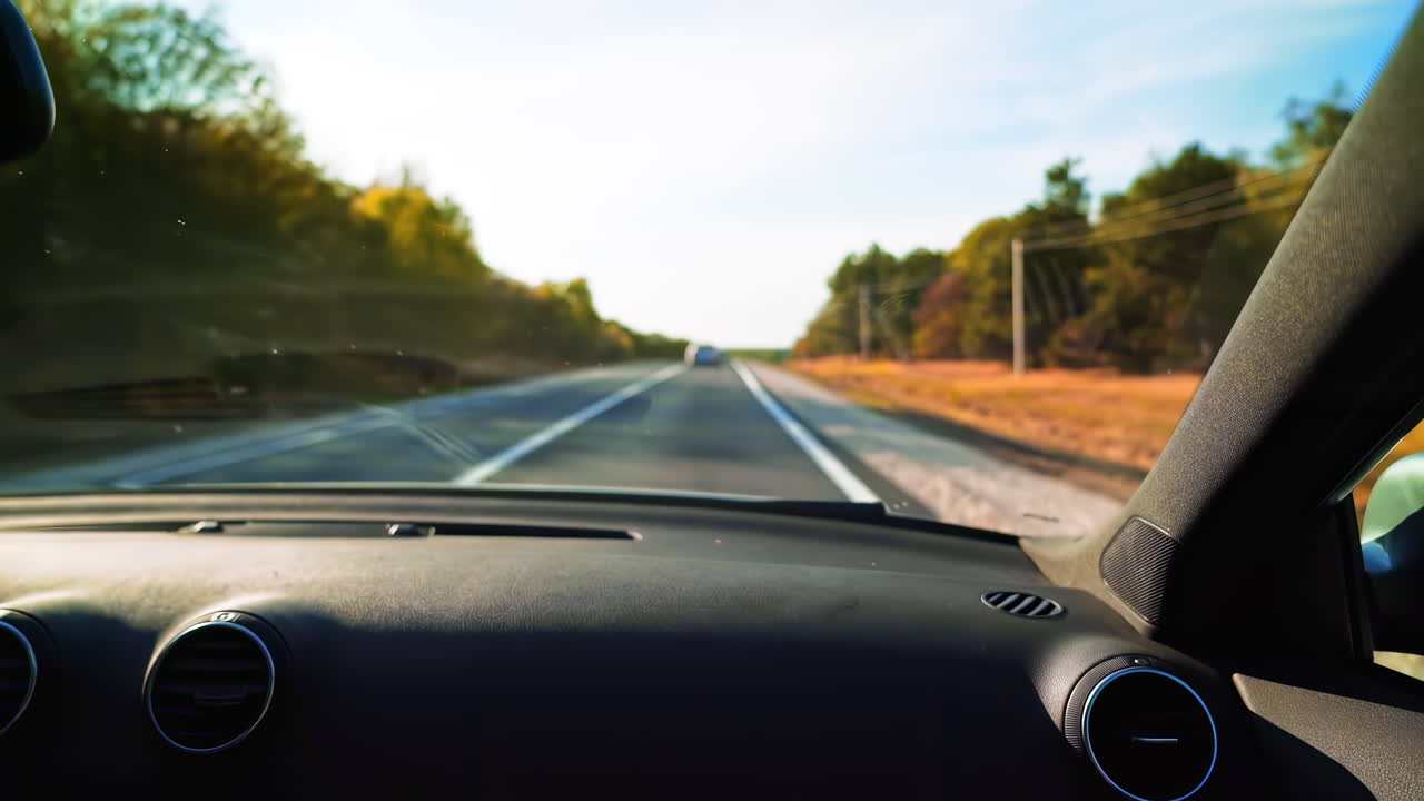 Ensbeliggende vej i Moldova med efterårstræer langs siden. Set fra bilen. Rejse- og turideer