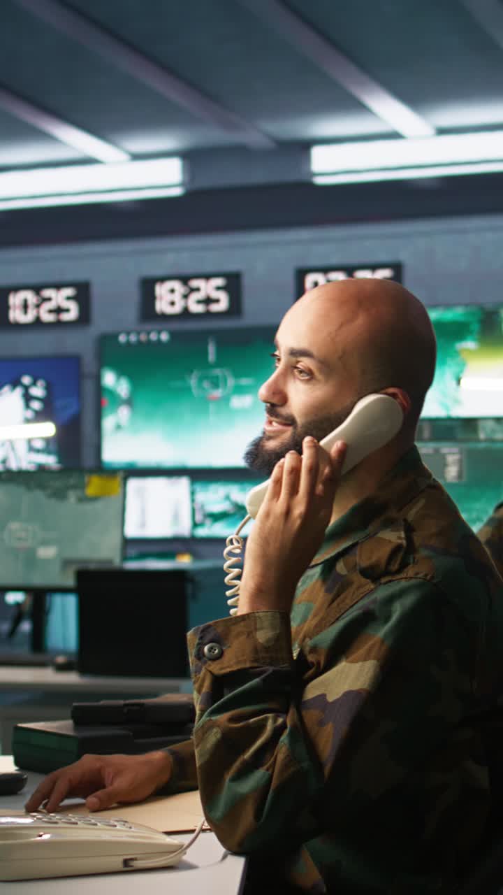 Vertical video Military officer receiving telephone call while looking at intel files