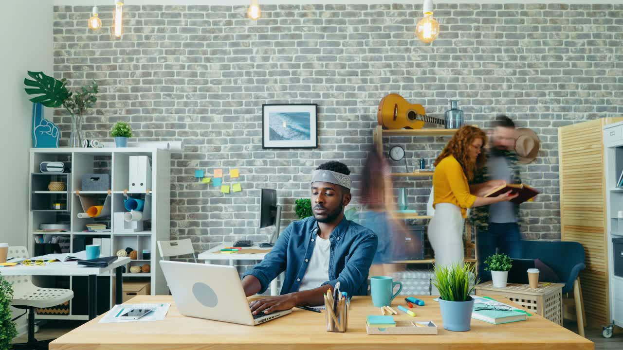 Time-lapse of African American man working with modern laptop in office