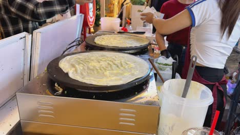 cooking crepes at a street food stall