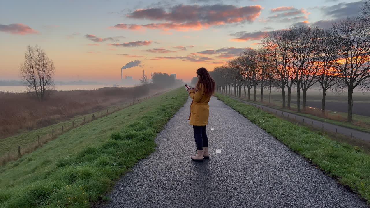 드론 컨트롤러를 손에 들고 이른 아침 비행에 집중하는 어린 소녀