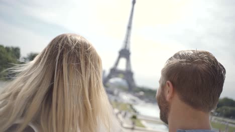 una pareja joven de 4k se hace una selfie en la ciudad de parís usando un teléfono móvil.