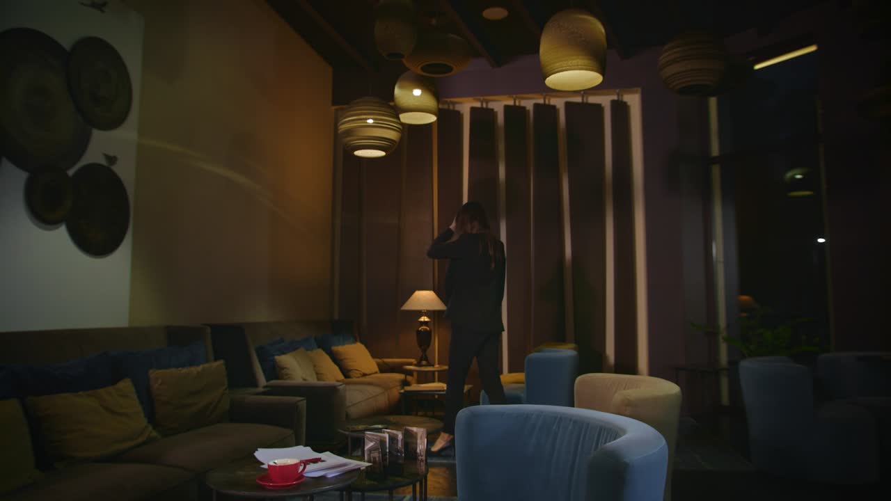 걱정하는 여자가 호텔 로비에서 기다리고 있습니다. 사업가는 호텔에서 노트북을 찾고 있습니다.