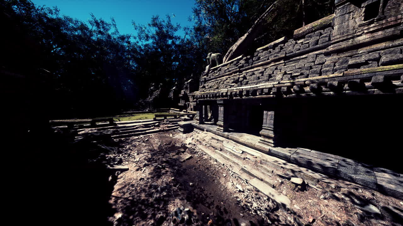Antiche rovine di un tempio cambogiano tra una vegetazione lussureggiante e la luce del sole.