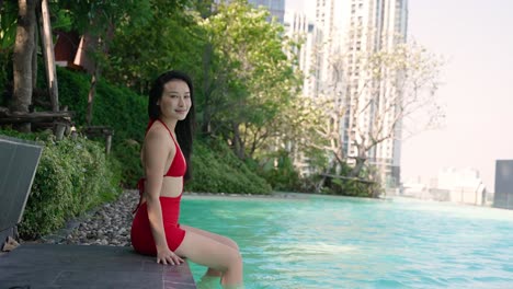 woman relaxing by the pool in a red swimsuit