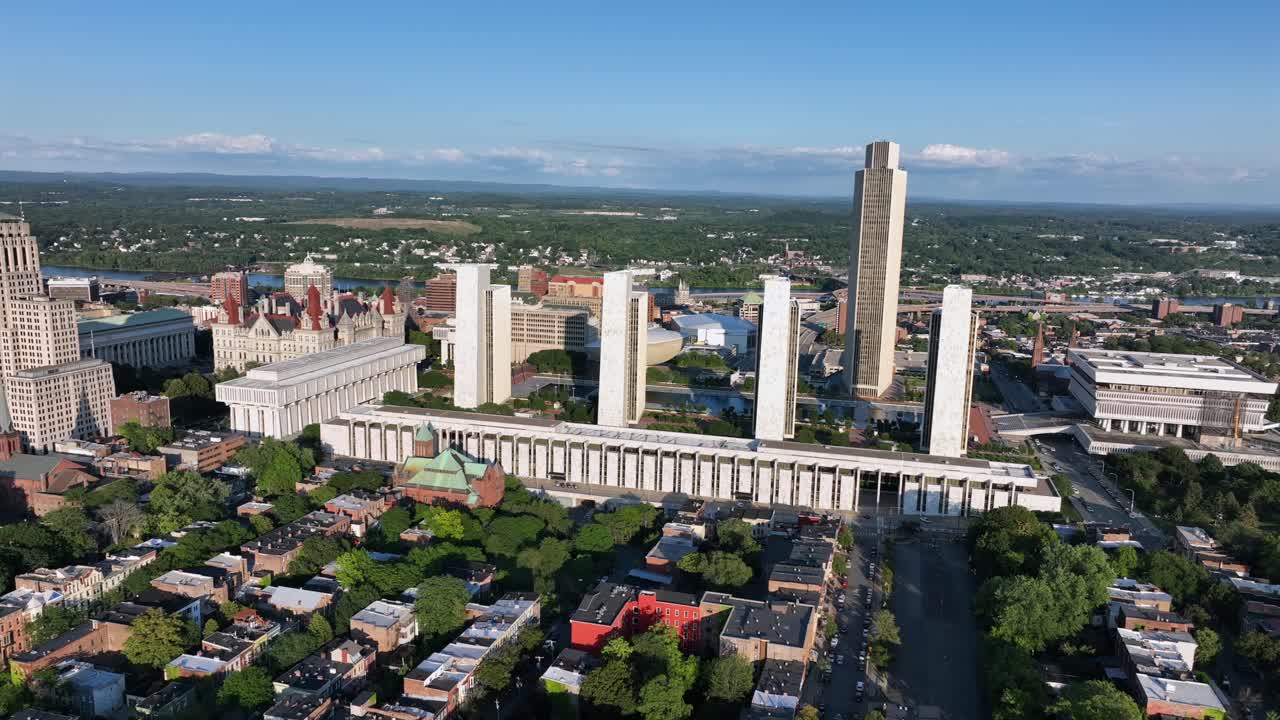 Aerial wide shot of Albany City in new York during sunset time. State office buildings at Empire State plaza. Housing area and residential in suburb district. Downtown in background. Orbit shot