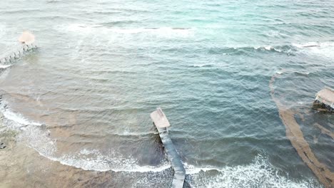 Olas-Salpicando-En-El-Muelle-Con-Cabañas-En-El-Mar-Caribe-En-Quintana-Roo,-México