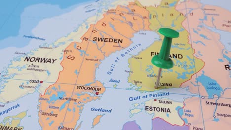 Finland---Travel-concept-with-green-pushpin-on-the-world-map.-The-location-point-on-the-map-points-to-Helsinki-the-capital-of-the-Finland.