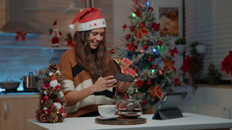 Festive-woman-receiving-gift-on-video-call-camera