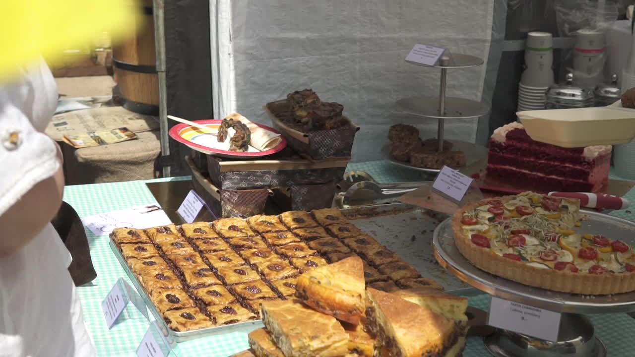 여자는 음식을 용기에 담는다, 도시 거리의 음식 축제, 사람들이 맛보는 지역 특산품
