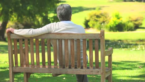 Mature-man-sitting-thinking-on-a-bench