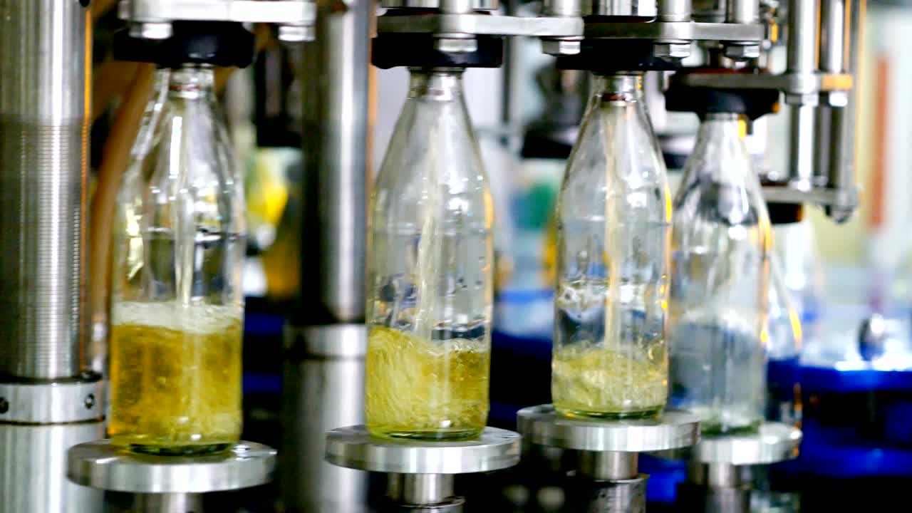 línea de máquina automática para llenar agua en una botella de vidrio. embotellado de bebidas a base de hierbas en botellas de vidrios. producción de agua potable y bebidas.