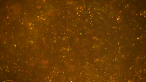 fondo de oro abstracto con movimiento caótico de burbujas. rotación de bolas, movimiento browniano molecular abstracto. caída hacia abajo.