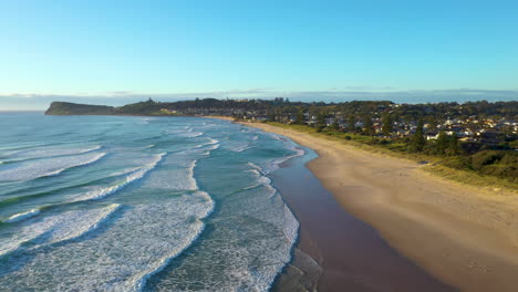 wide rotating drone shot of lennox head beach and coastline