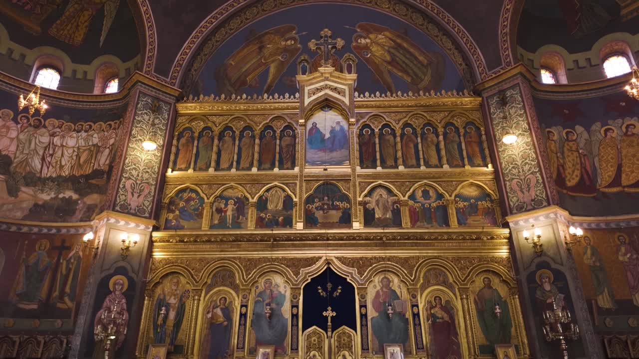 Interior view highlighting the ornate golden altar, sacred iconography, and colorful frescoes inside Sibiu’s Holy Trinity Orthodox Cathedral