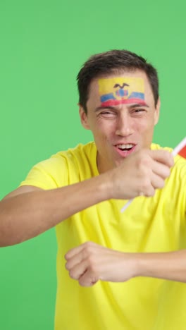 man cheering for ecuador screaming and waving a national flag