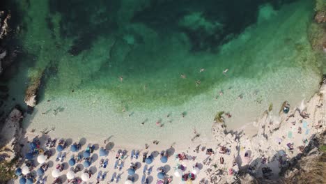 Vista-Aérea-De-Las-Aves-De-La-Concurrida-Playa-De-Kassiopi-Con-Filas-De-Sombrillas