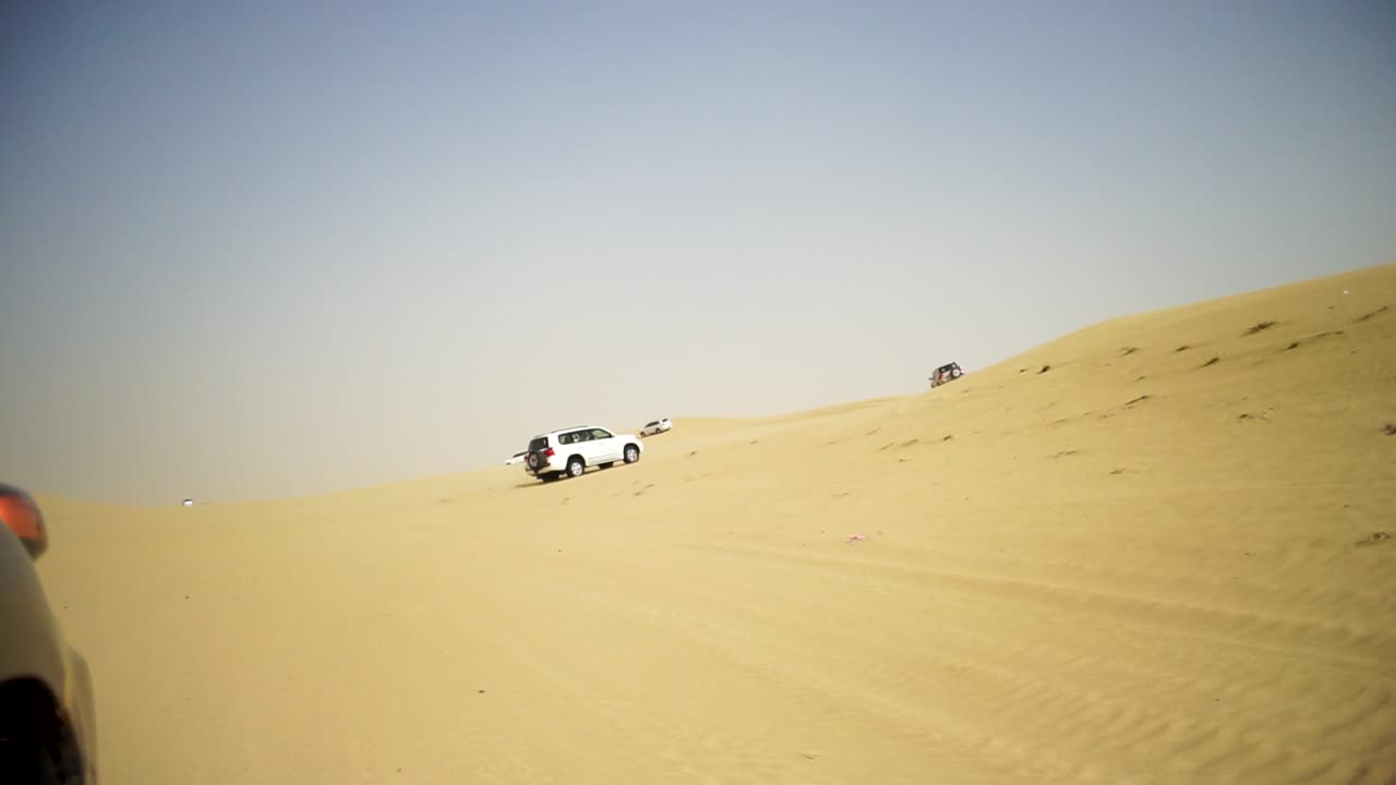 사막의 모래 언덕을 가로질러 운전하는 4x4 차량