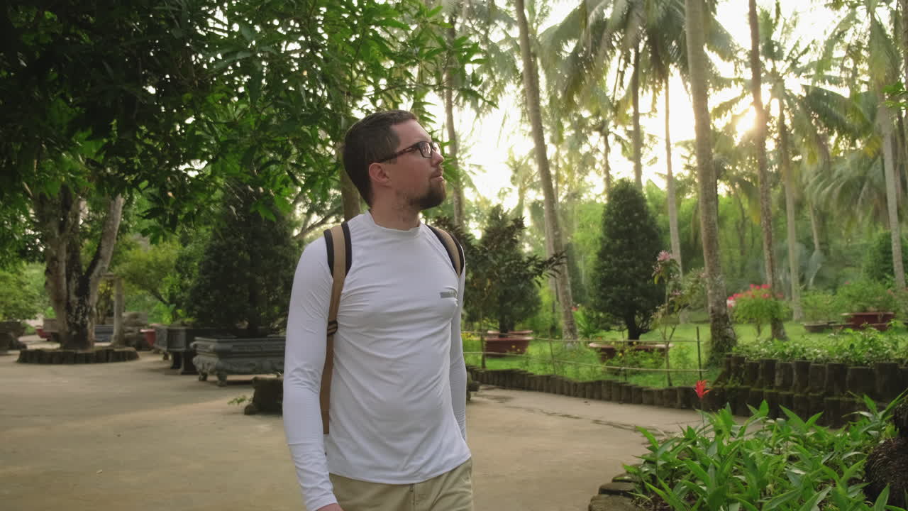 Man Walking Through a Tropical Garden