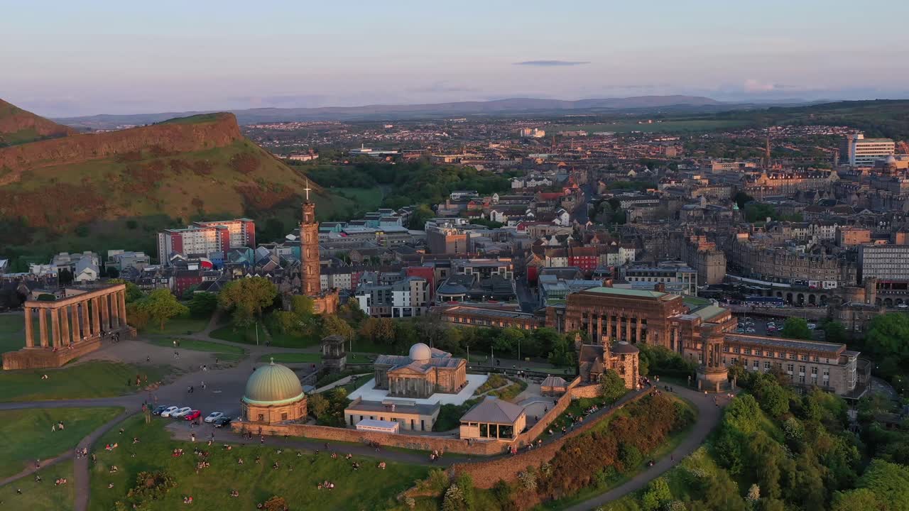 Aerial rotating shot of Arthurs's seat, the national monument of Scotland and Edinburgh Castle drone