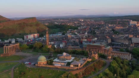 Aerial-rotating-shot-of-Arthurs's-seat,-the-national-monument-of-Scotland-and-Edinburgh-Castle-drone