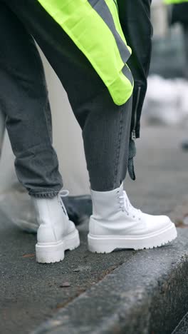 woman cleaning street with yellow vest