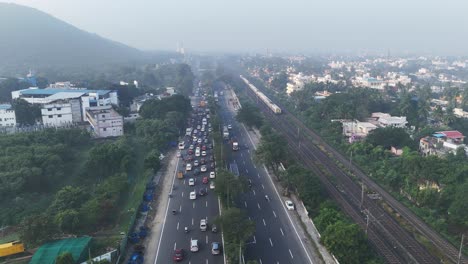 early morning aerial video of chennai. the city awakens: aerial footage of morning traffic on gst road, chennai. train passing