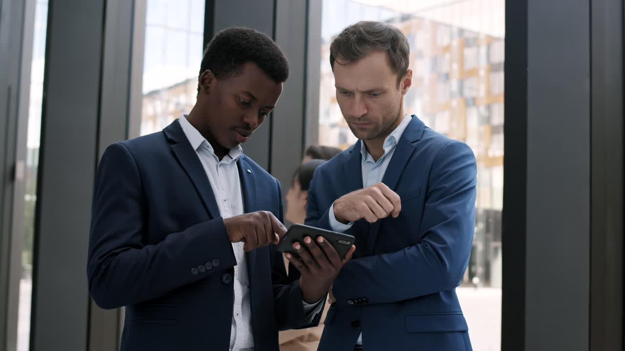 dos hombres de negocios usando un teléfono inteligente en la sala de la oficina