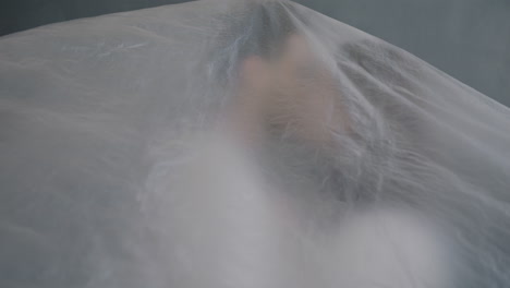 Couple Kissing Under a Plastic Sheet