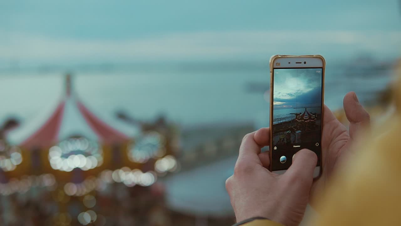 tomando una foto de una puesta de sol sobre el mar desde un carrusel