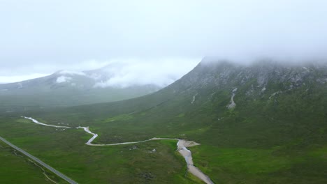 Panorámica-Amplia-Toma-De-Drones-En-Las-Nubes-De-Las-Tierras-Altas-Escocesas-De-Carretera-Remota