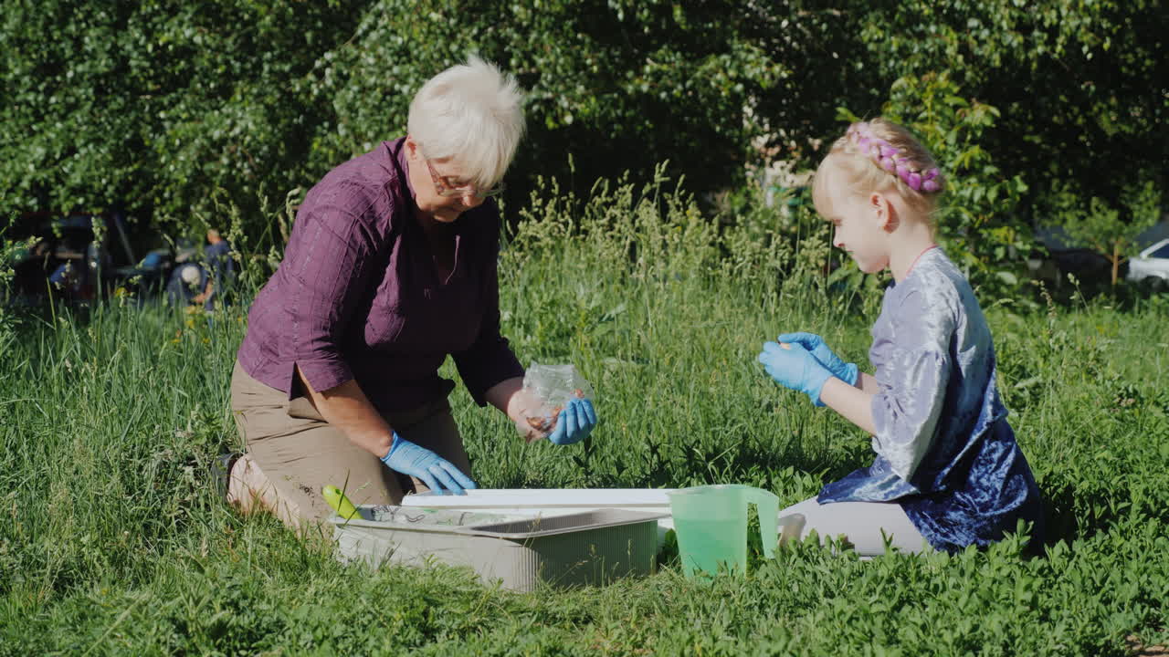 бабушка и внучка вместе сажают цветы во дворе активная концепция пожилых людей