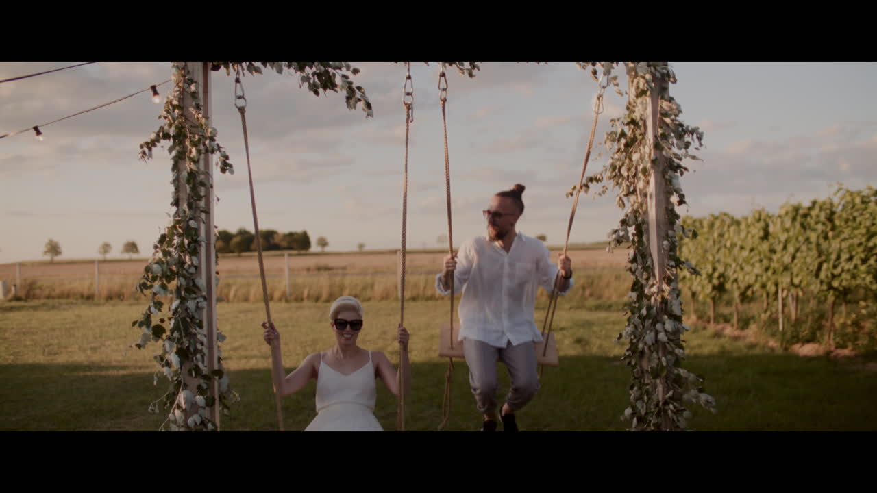 Couple Swinging on a Swing in a Field