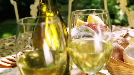 close-up of food and white wine on table