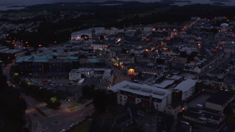 Aerial-shot-of-city-centre.-Buildings-and-streets-in-evening.-Cars-driving-on-road-and-parking-in-square.-Killarney,-Ireland