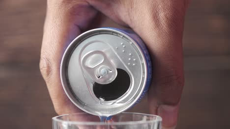 pouring energy drink from a can into a glass