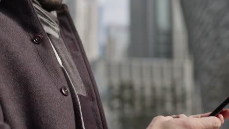 business man close up chatting texting with smartphone, caucasian male model wearing fancy winter modern clothing