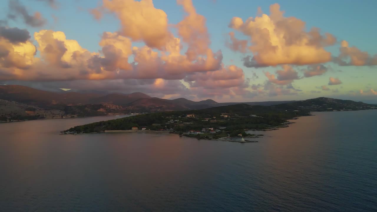 Isola greca all'ora d'oro del tramonto con paesaggio montano e nuvole colorate