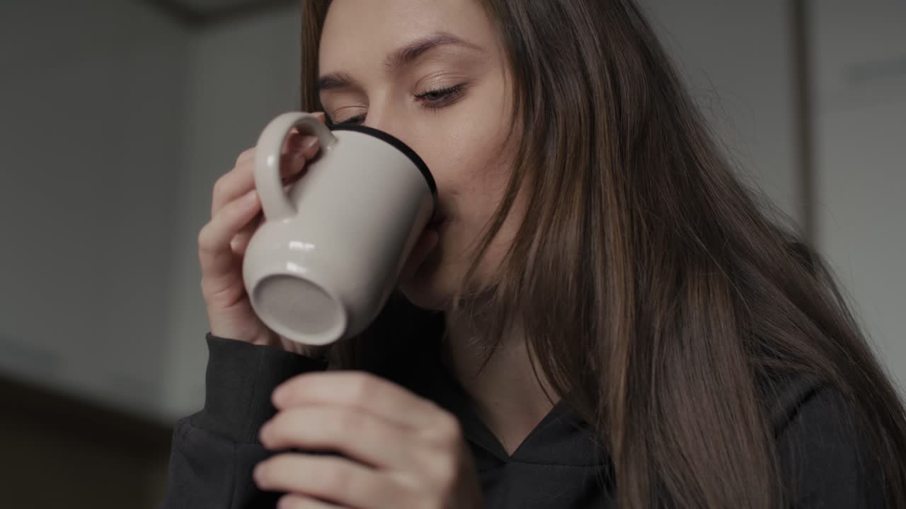 Mujer caucásica triste sentada en el sofá con una taza de café