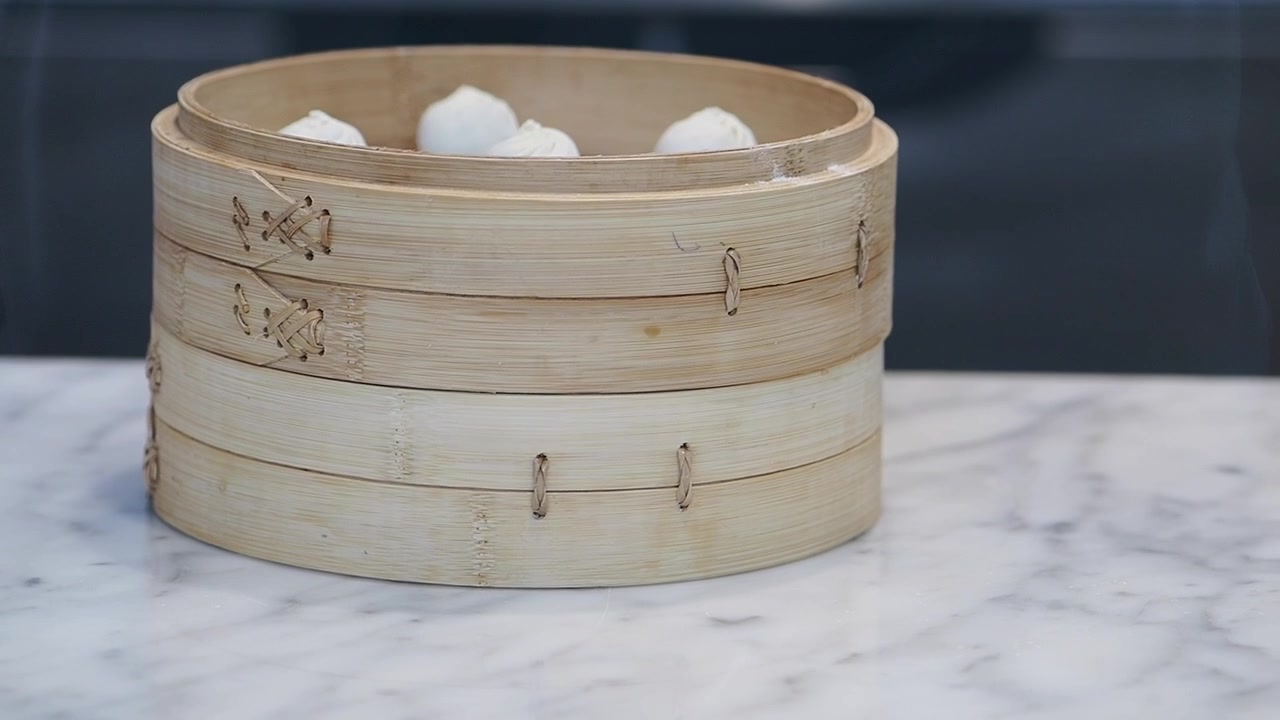 Keranjang Dim Sum Bambu yang Mengepul di Atas Meja Marmer