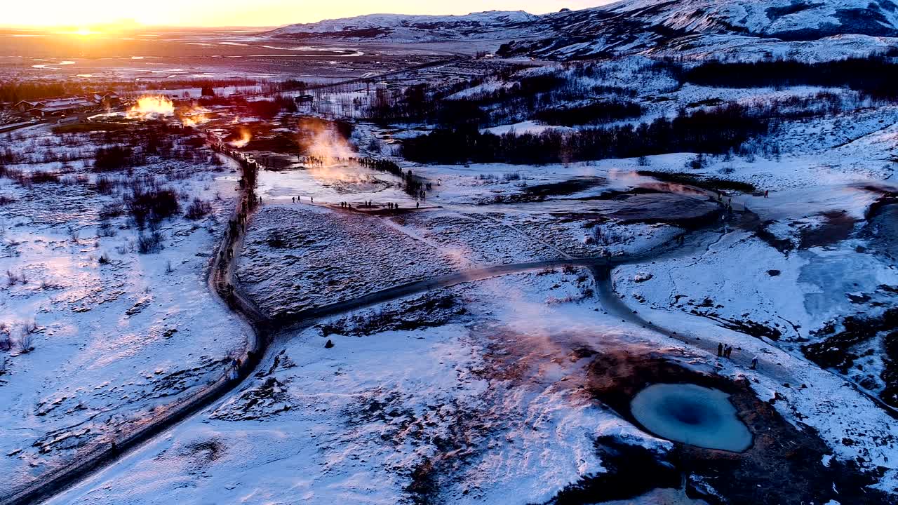 아이슬란드의 게이시르 (geysir) 에서 은 해가 지는 아래 산의 파노라마 뷰. 여행객들에게 유명한 멋진 장소에 게이저가 있습니다. 게이저에서 많은 연기가 나오고 있습니다.