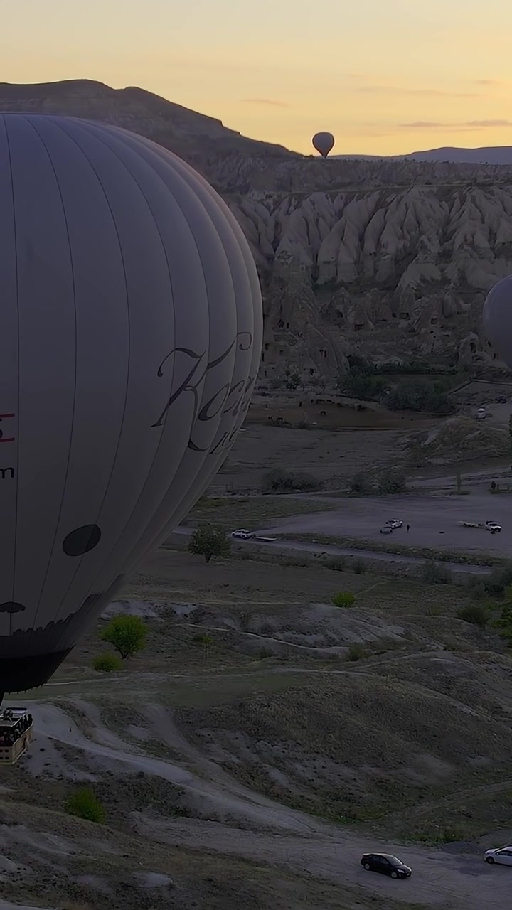 Mongolfiere sorvolano la Cappadocia all'alba durante un giro in mongolfiera.